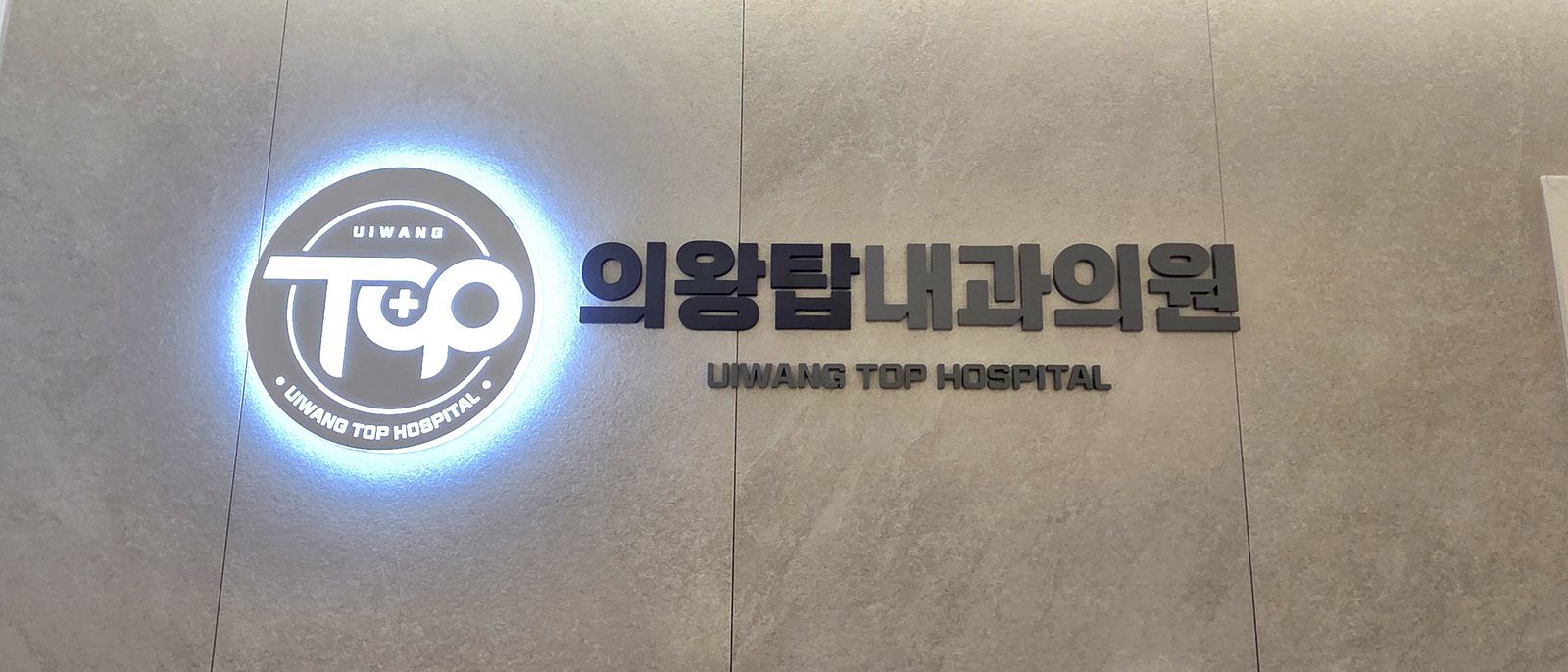 조명 로고가 설치된 의왕탑내과 내부 벽면